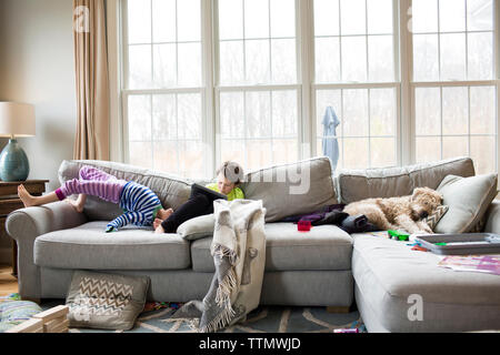 Siblings on sofa at home Stock Photo