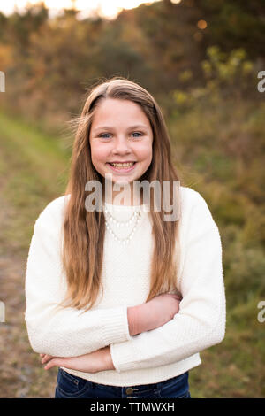 Smiling 13 Year Old Girl Stands Confidently at Sunset on Trail Stock Photo