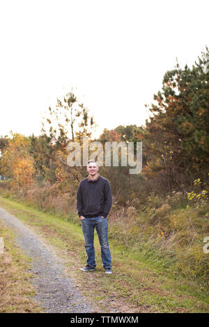 Wide View of Smiling 20 Year Old Man Standing on Trail at Sunset Stock Photo