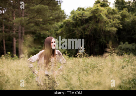 Smiling Teenage Girls Stands in Green Field in Front of Woods Stock Photo