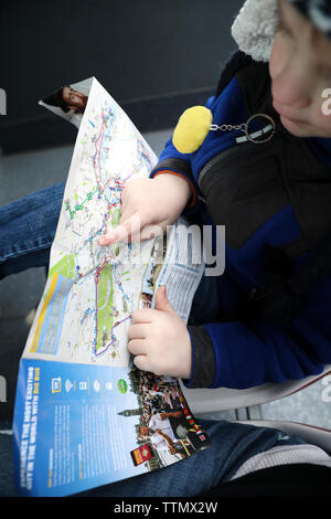 Close Up of Young Boy Pointing at Bus Routes on Map Stock Photo