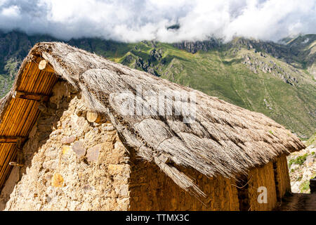 Inca storage house with mountain in the background Stock Photo