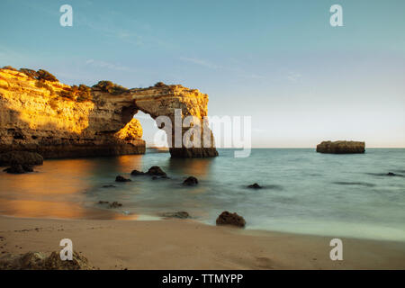 Scenic view of natural arch in sea at Algarve against clear sky Stock Photo