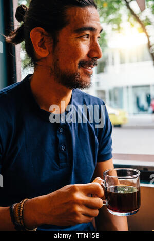 Thoughtful mature man with black coffee looking away in cafe Stock Photo