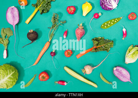 Overhead view of fresh vegetables over turquoise background Stock Photo