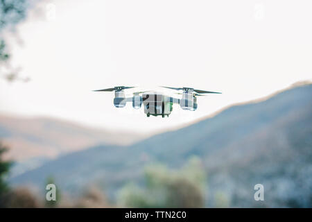 Close-up of quadcopter flying against clear sky Stock Photo