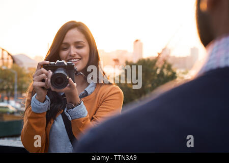 Couple taking pictures on footbridge in city Stock Photo