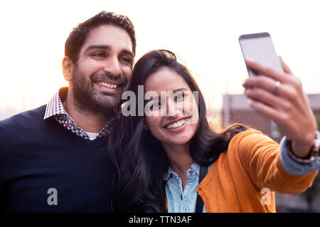 Couple taking selfies at sunset Stock Photo