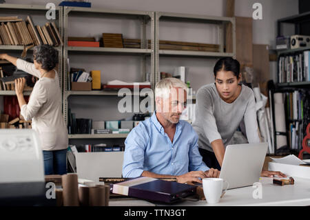Multi-ethnic interior designers using laptop in creative office Stock Photo