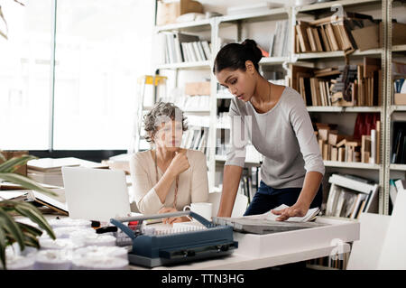 Interior designers discussing over tile sample in creative office Stock Photo