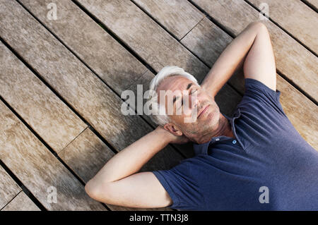 Overhead view of mature man relaxing on floorboard Stock Photo