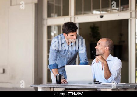 business people discussing while sitting at table in office Stock Photo