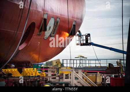 Worker repairing container ship at industry Stock Photo