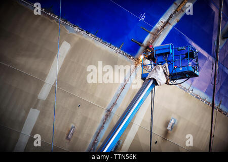 Low angle view of worker welding container ship at industry Stock Photo
