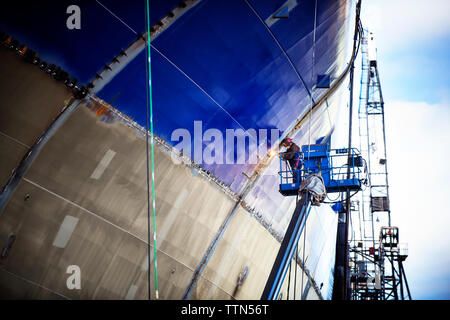 Low angle view of worker welding ship at industry Stock Photo