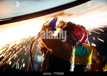 workers welding airplane wing at industry during night Stock Photo
