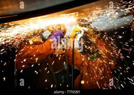 Mechanics welding airplane wing at industry during night Stock Photo