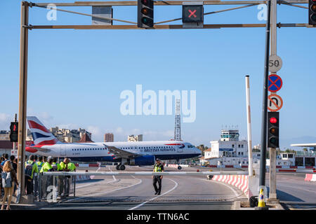 Gibraltar International Airport. British Airways flight to London just lifting off from runway at 150mph+ as it crosses the main road to Spain Stock Photo