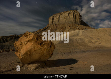 Low angle scenic view of rock formation against cloudy sky at Grand Staircase-Escalante National Monument during night Stock Photo