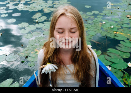 Close-up of happy woman with eyes closed sitting in boat on lake Stock Photo