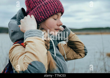 Beautiful girl by the river wearing knitted hat