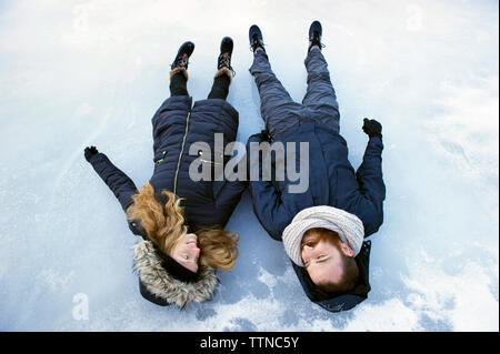 Couple lying on frozen lake Stock Photo