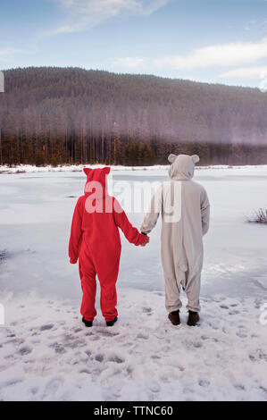 Couple wearing costumes and holding hands Stock Photo