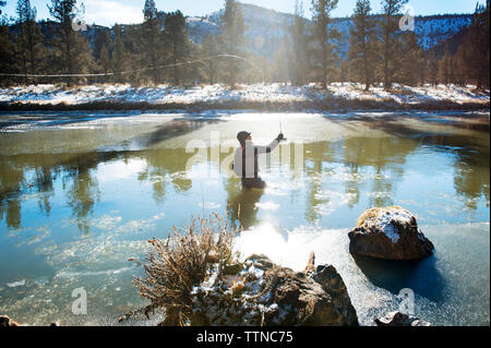 Man preparing fly fishing pole at sunny river Stock Photo - Alamy