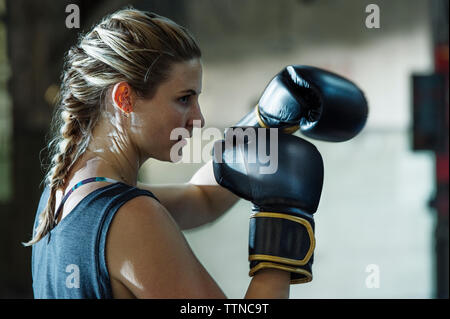 Side view of confident female boxer in gym Stock Photo