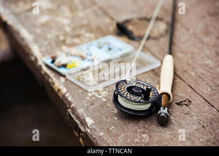 Close-up of fishing rod and hooks on wooden table outdoors Stock Photo