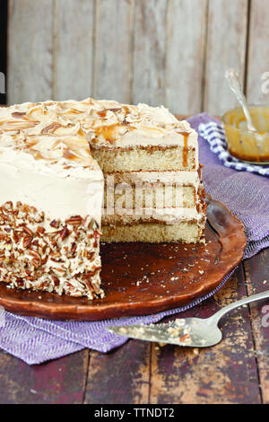 Close-up of butterscotch cake in plate on wooden table at home Stock Photo