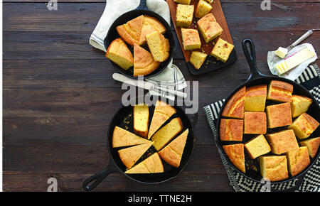 High angle view of corn breads in saucepans with napkins on wooden table at home Stock Photo
