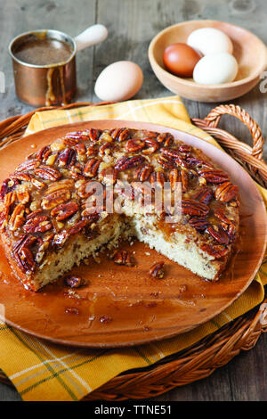 High angle view of pecan cake served in plate with eggs and syrup on wooden table at home Stock Photo