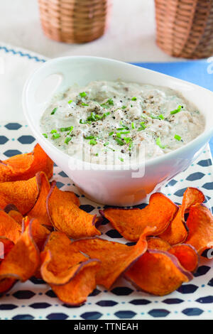 Close-up of sweet potato chips with onion dip served on table at home Stock Photo
