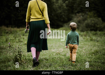 Anonymous mother and her son walking together  in the forest. Stock Photo