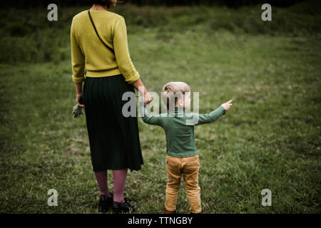 Anonymous mother and her son walking together  in the forest. Stock Photo