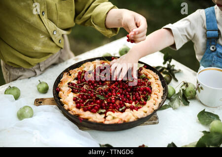 Brothers eating sweet pie in yard Stock Photo