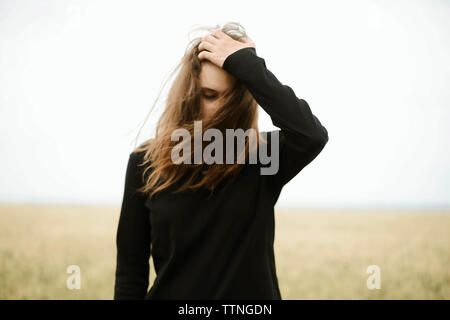 Young woman stands in a wheat field in summer Stock Photo