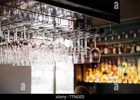 Wineglasses hanging upside down in restaurant Stock Photo