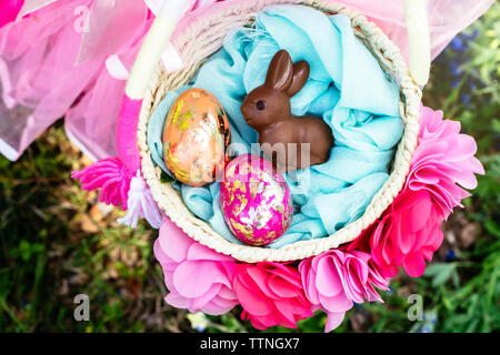 Overhead view of girl with easter eggs and bunny in basket Stock Photo