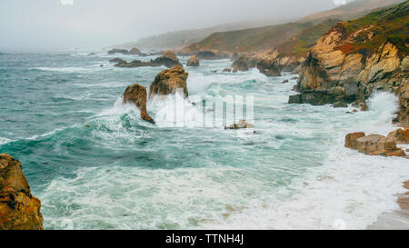 High angle scenic view of waves splashing on rocks Stock Photo