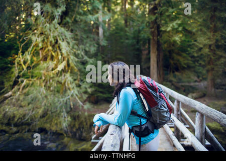 Young woman leaning on wooden bridge Stock Photo