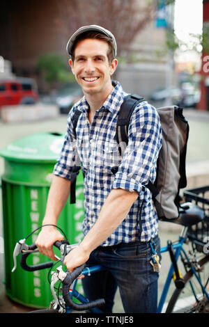 Portrait of happy man with bicycle on city street Stock Photo