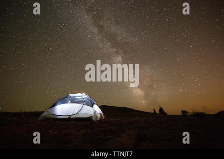 Illuminated tent on field against starry sky at night Stock Photo