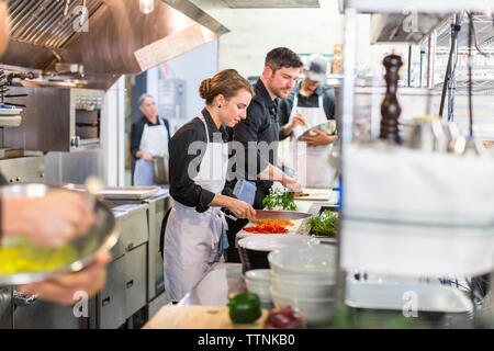 Chefs preparing food in kitchen at restaurant Stock Photo
