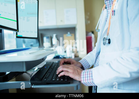 Midsection of male doctor using desktop computer in hospital ward Stock Photo