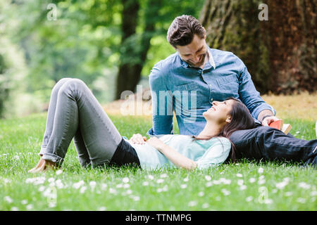 Happy girlfriend lying on boyfriend's lap in park Stock Photo