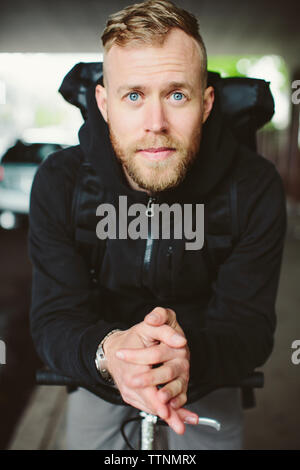 Portrait of male commuter with bicycle standing on street Stock Photo
