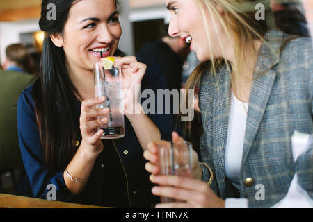 Happy friends talking while having drinks in restaurant Stock Photo