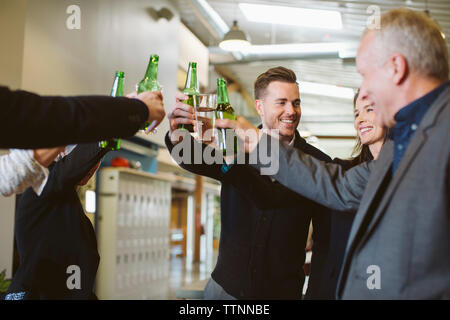 Happy business people toasting drinks in office Stock Photo